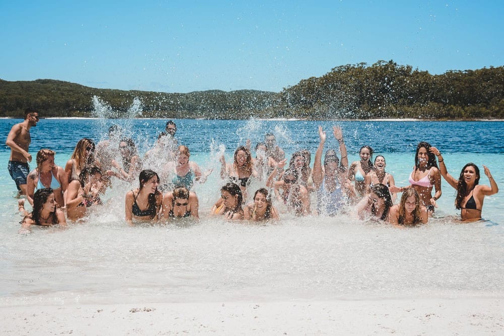 Viaje Fraser Island grupo de estudiantes en el agua con bikini salpicándose entre todos